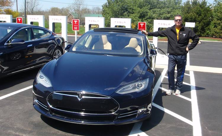 Ivon Lemire posant fièrement à côté de sa Tesla en charge à une Superborne (USA). MERCI POUR LE VIDÉO IVON!